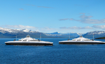 Two boats on water with mountains in background